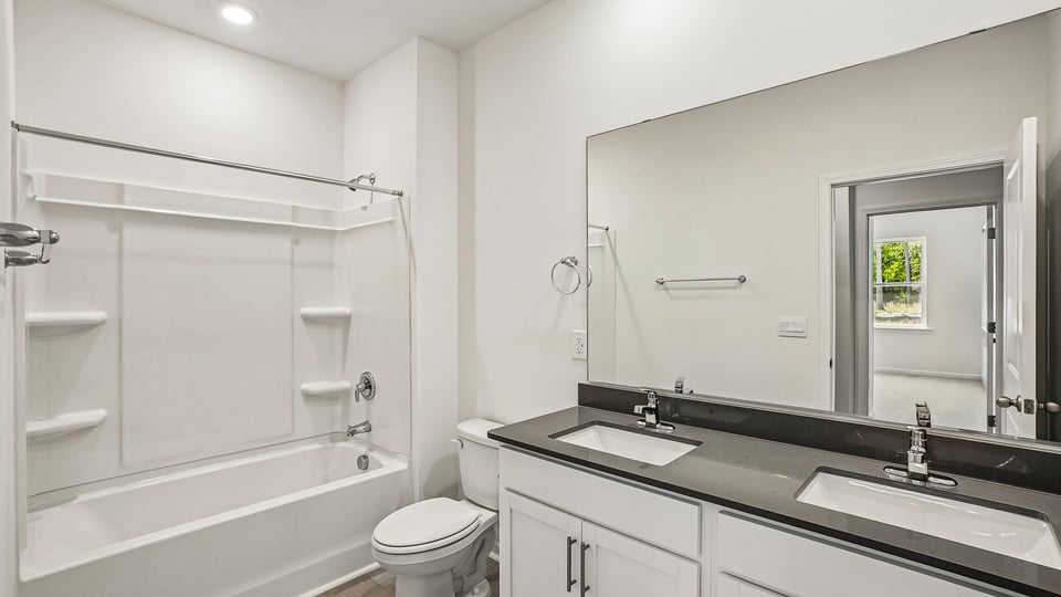secondary bathroom with shower tub combo and dual vanity sink