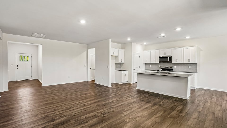 kitchen with quartz counters, kitchen island, pantry, stainless steel appliances