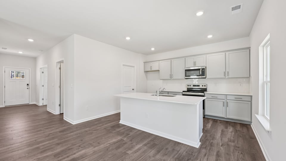 kitchen with quartz counters, kitchen island, pantry, stainless steel appliances