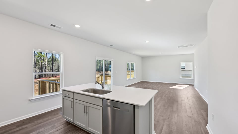 kitchen with quartz counters, kitchen island, pantry, stainless steel appliances