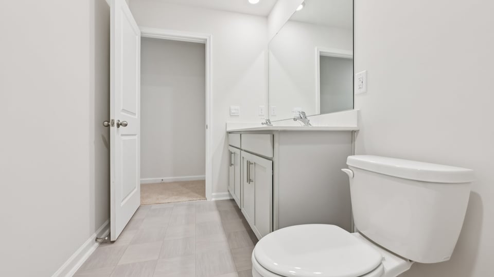 secondary bathroom with shower tub combo and dual vanity sink