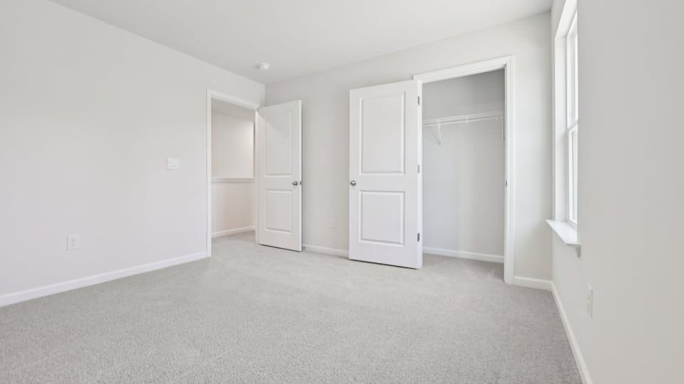 secondary bedroom with window and closet, carpeting