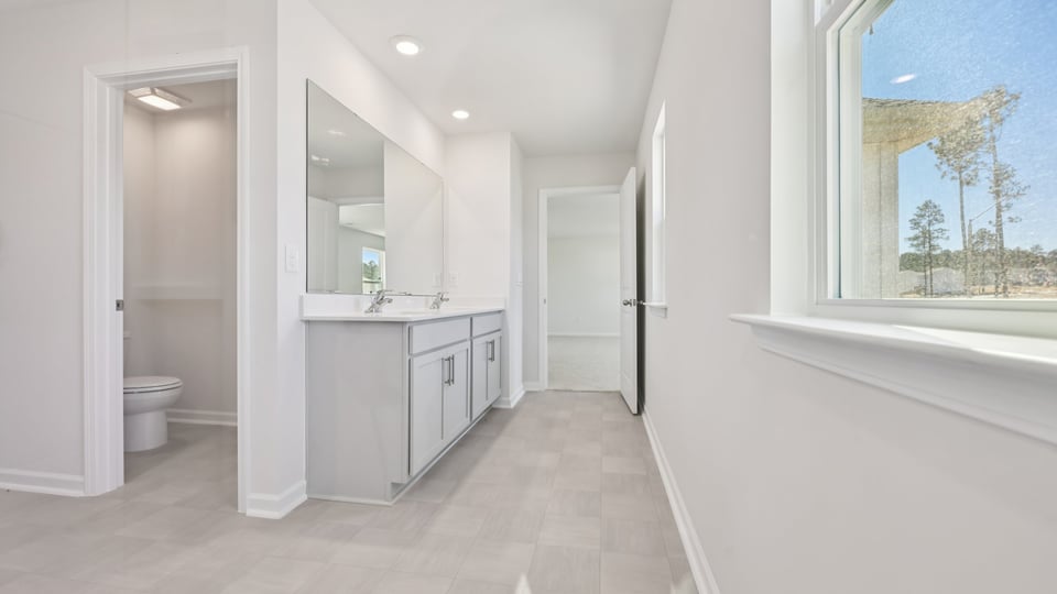 primary bathroom with walk in shower and dual vanity sinks