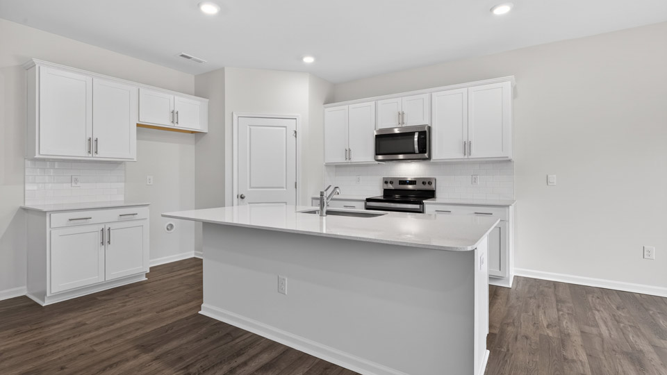 kitchen with quartz counters, kitchen island, pantry, stainless steel appliances