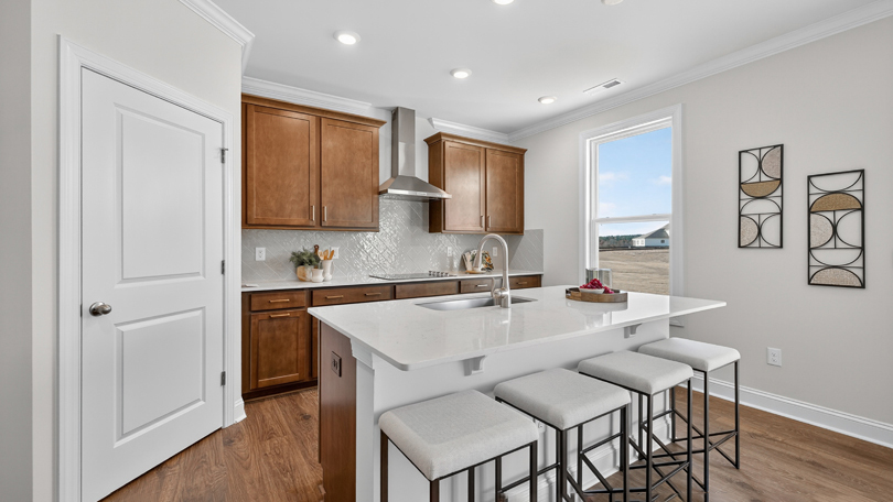 kitchen with brown cabinets quartz countertops tile backsplash and stainless steel appliances