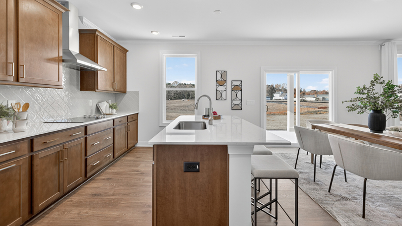 kitchen with brown cabinets quartz countertops tile backsplash and stainless steel appliances