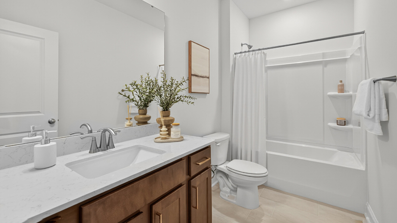 bathroom with brown cabinets and a tub shower combo