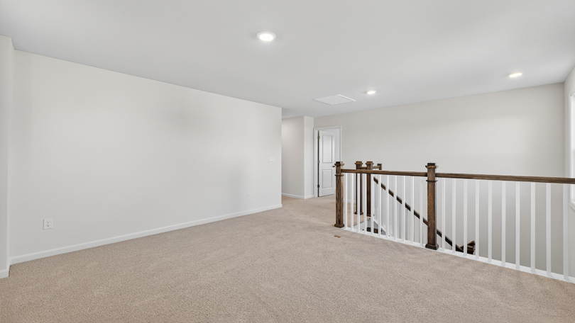 loft with open-rail staircase and carpet flooring