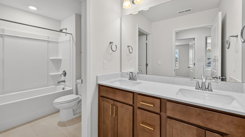 bathroom with brown cabinets and a tub shower combo