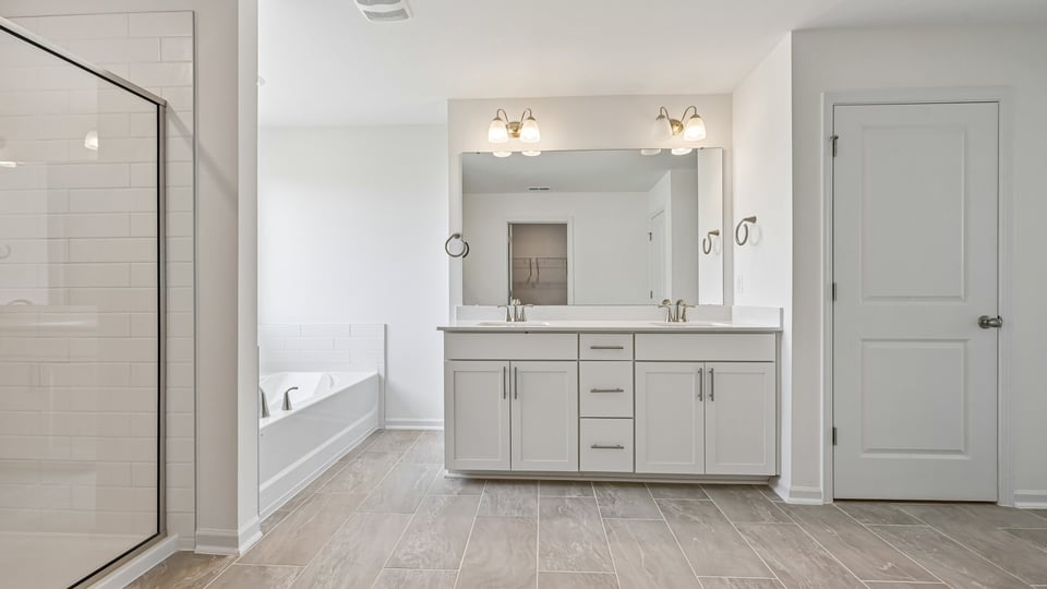 primary bathroom with dual vanity and separate tub and shower