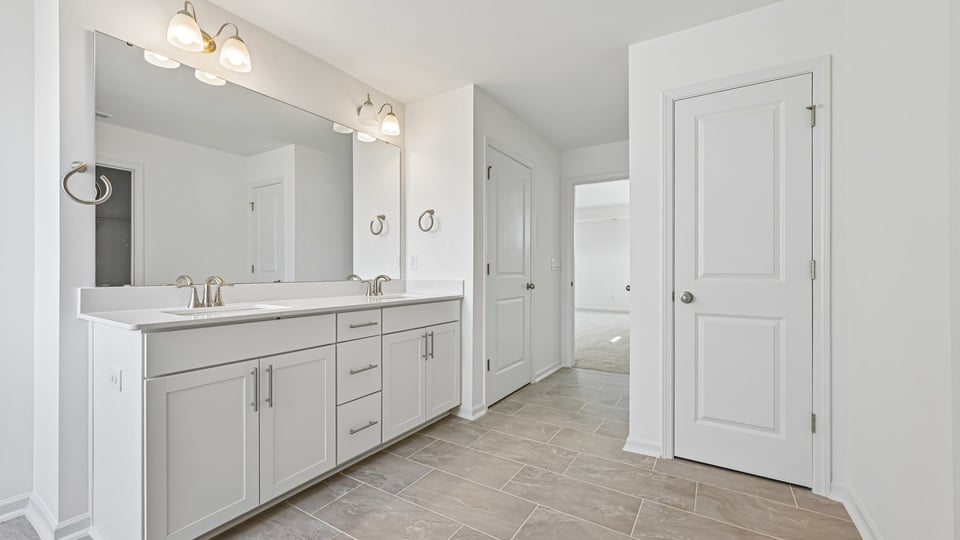 primary bathroom with dual vanity and quartz countertops