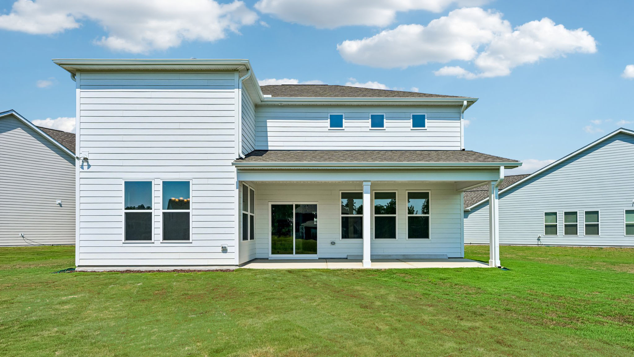 back of home with covered concrete patio