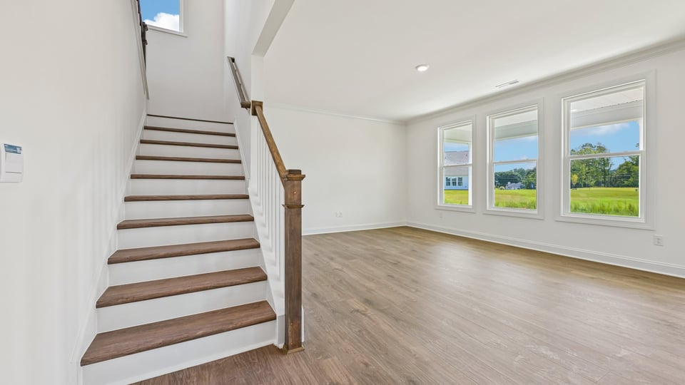 entering living area of home with open rail staircase