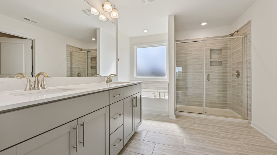 primary bathroom with dual vanity and separate tub and shower