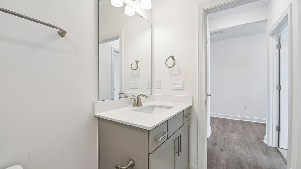 bathroom with gray cabinets and quartz countertops