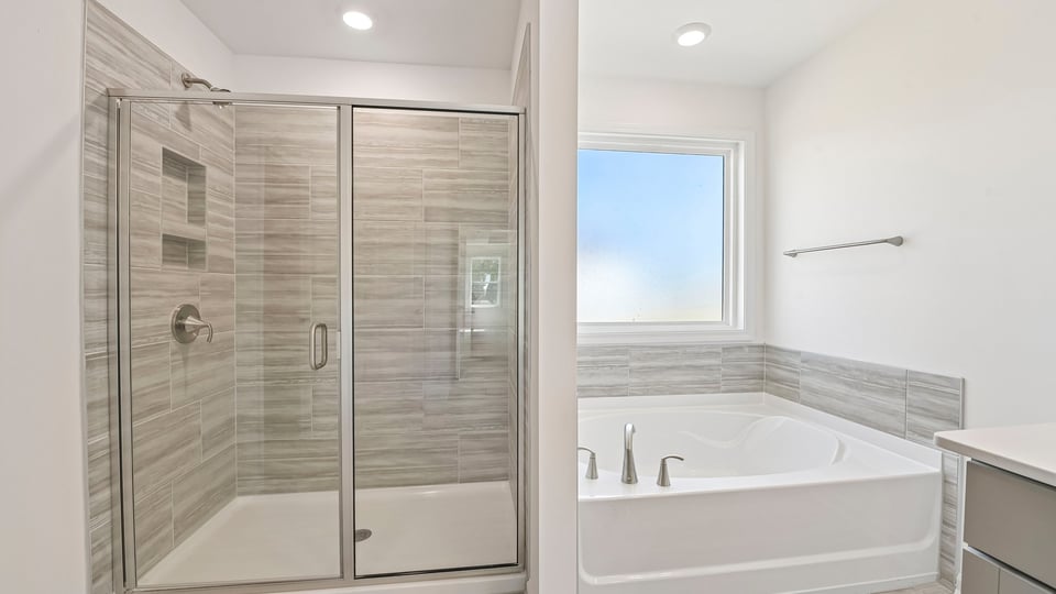 primary bathroom with separate tub and walkin shower