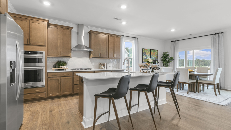 kitchen with brown cabinets spacious island and quartz countertops