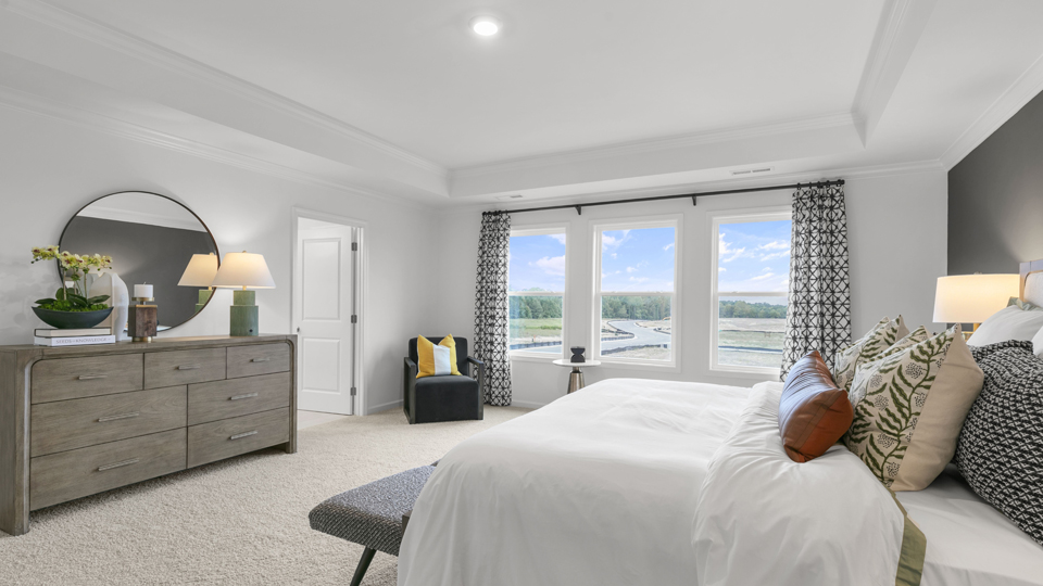 primary bedroom with tray ceiling and carpet flooring