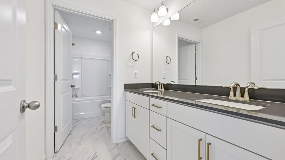 bathroom with dual vanity and quartz countertops