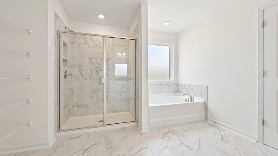 primary bathroom with separate tub and walkin shower