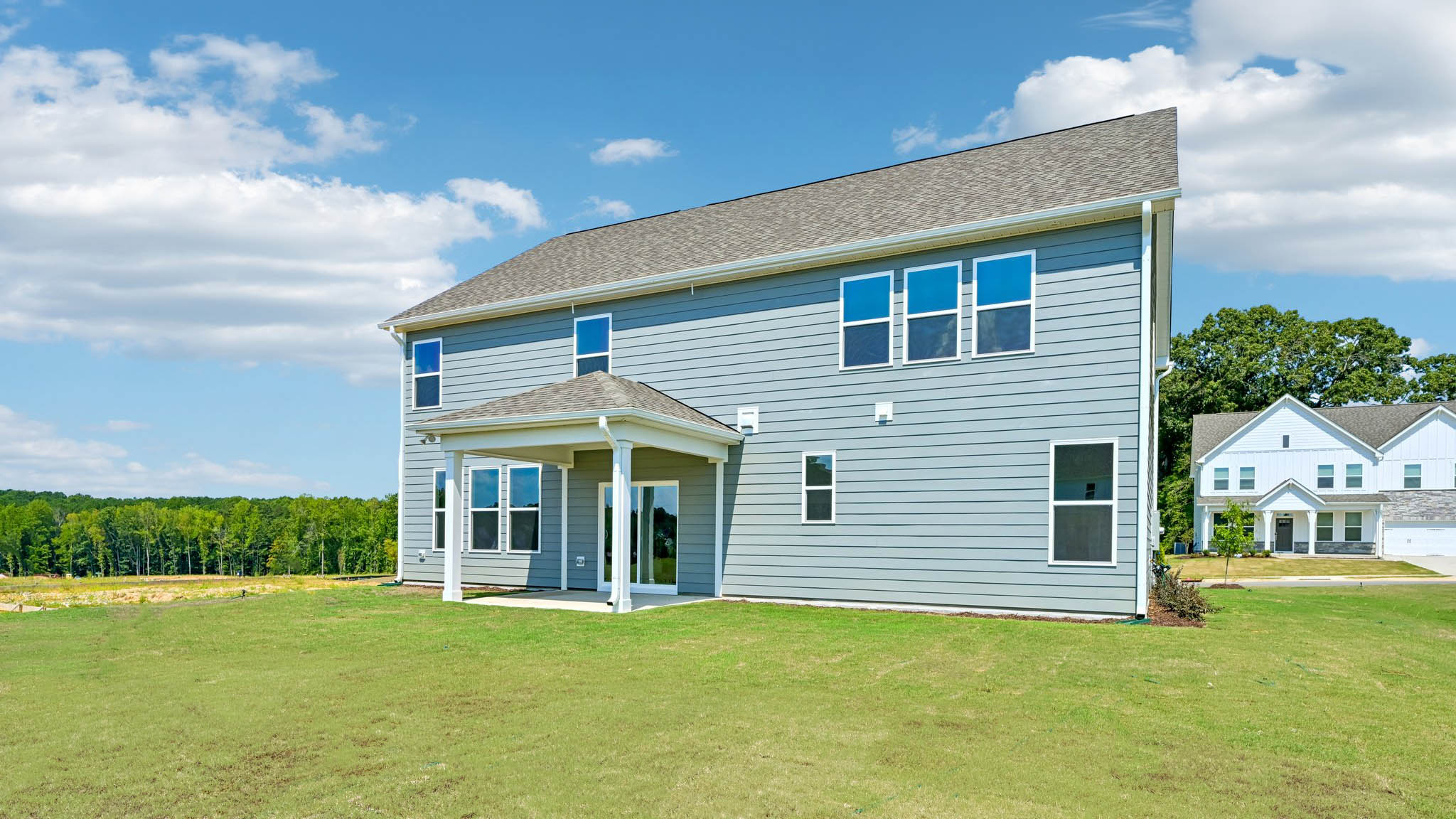 back of home with covered concrete patio