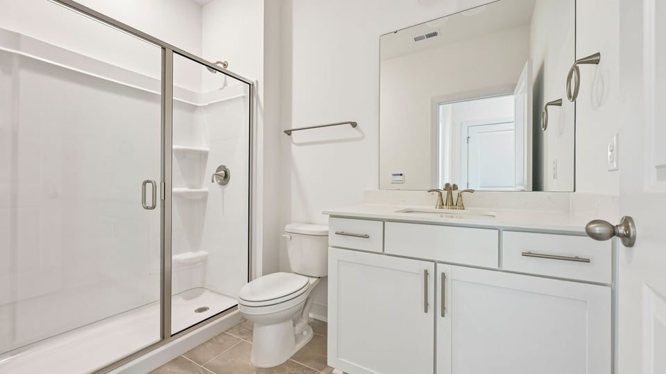 bathroom with walkin shower and white cabinets