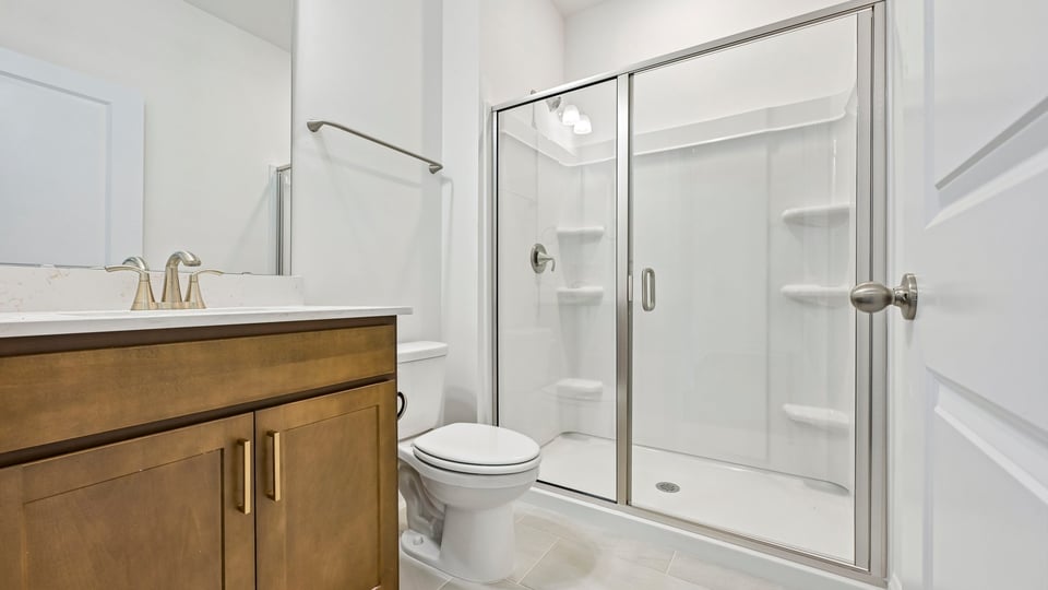 bathroom with brown cabinets and walkin shower