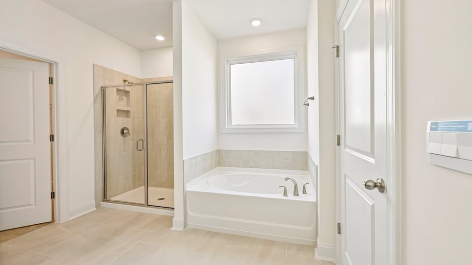 primary bathroom with separate tub and walkin shower