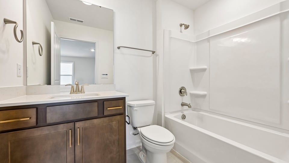 bathroom with brown cabinets and tub shower combo