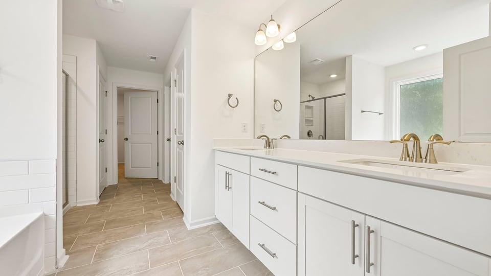 bathroom with white cabinets and dual vanity
