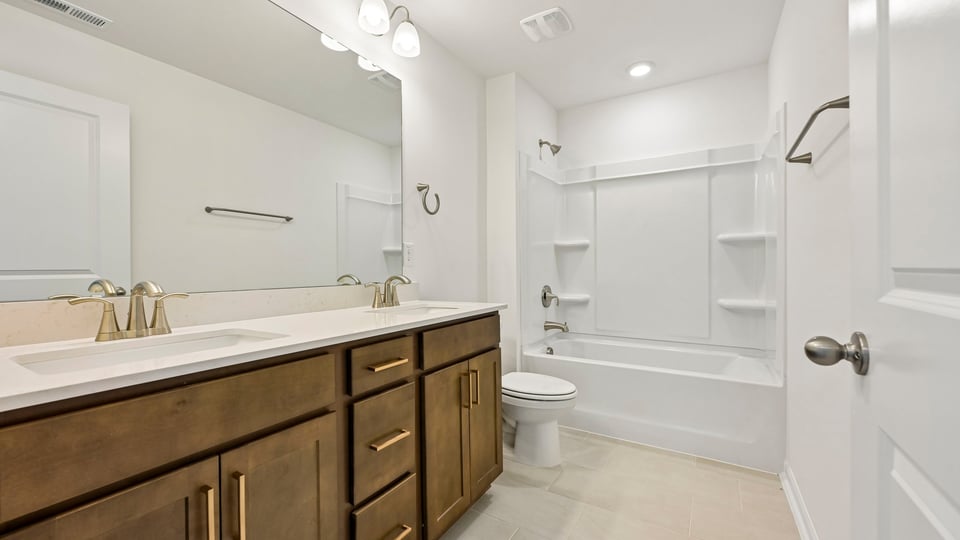 bathroom with brown cabinets and tub shower combo