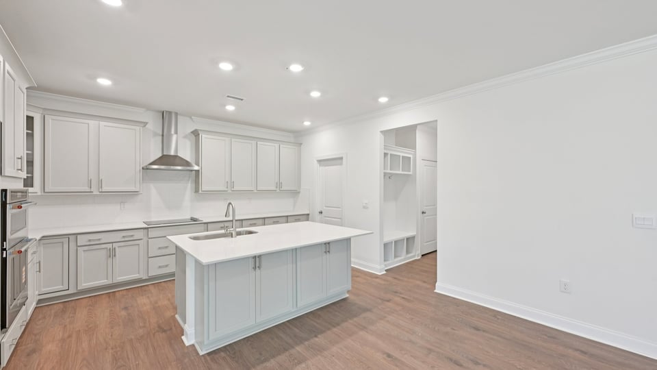 kitchen with quartz counters, kitchen island, pantry, stainless steel appliances