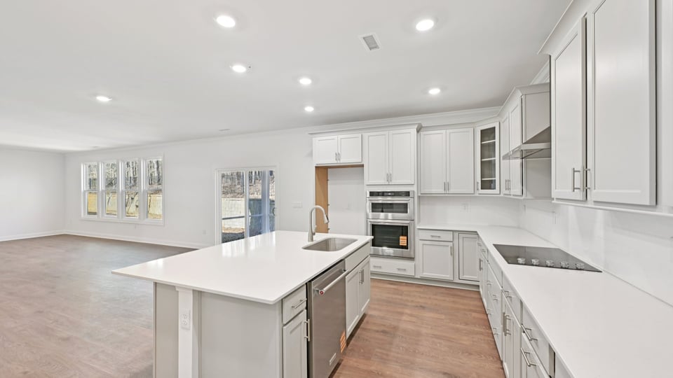 kitchen with quartz counters, kitchen island, pantry, stainless steel appliances