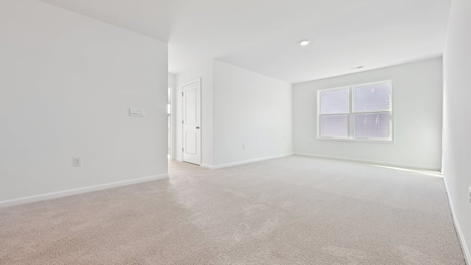 upstairs loft area with large windows and carpeting
