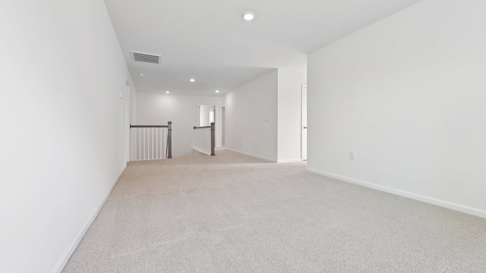 upstairs loft area with large windows and carpeting