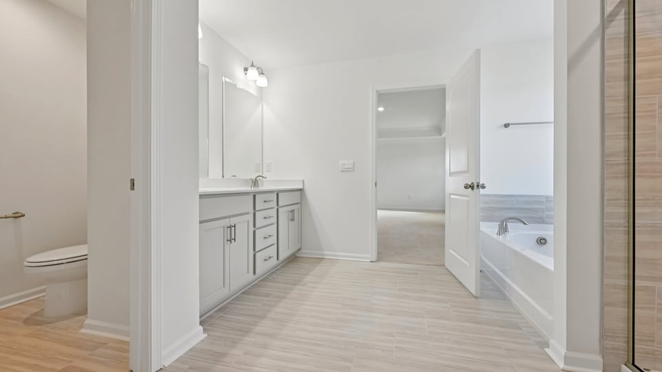 primary bathroom with walk in shower, bathtub, and dual vanity sinks