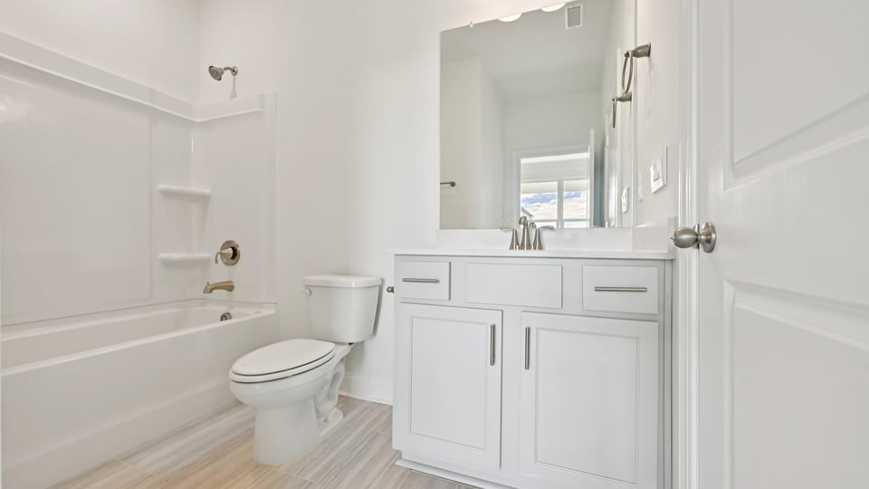 secondary bathroom with tub shower combo and quartz countertops