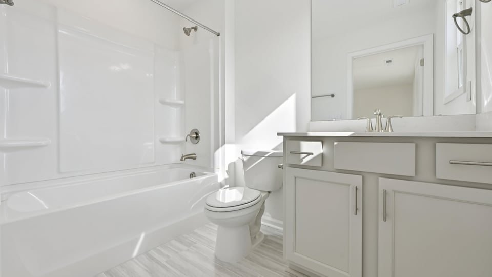 secondary bathroom with tub shower combo and quartz countertops