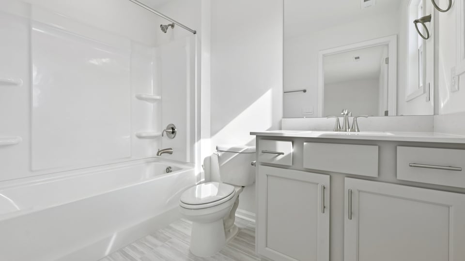 secondary bathroom with tub shower combo and quartz countertops
