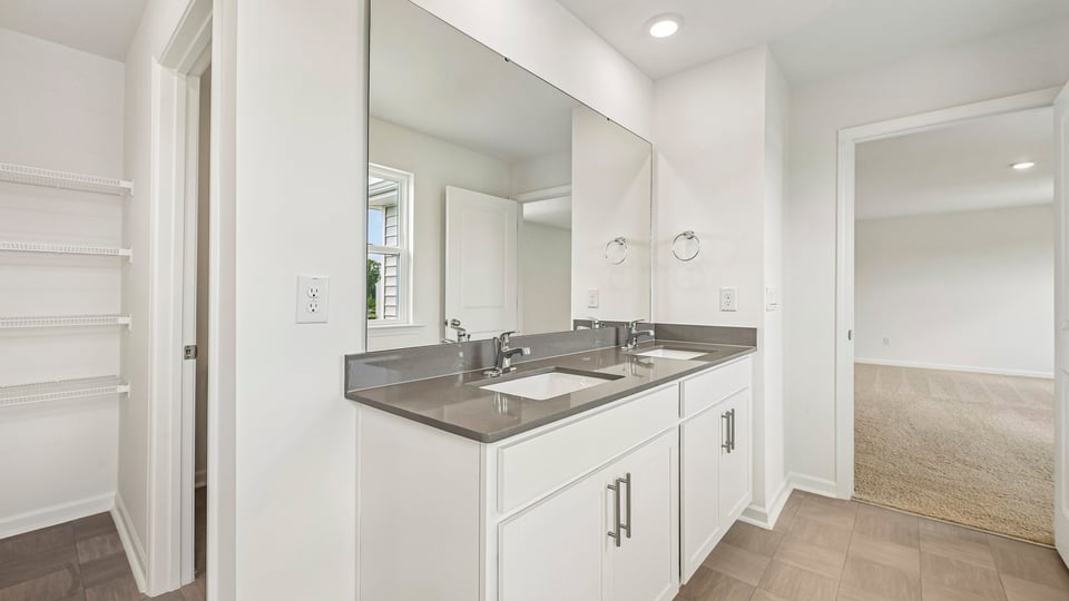 bathroom with dual vanity white cabinets and quartz countertops