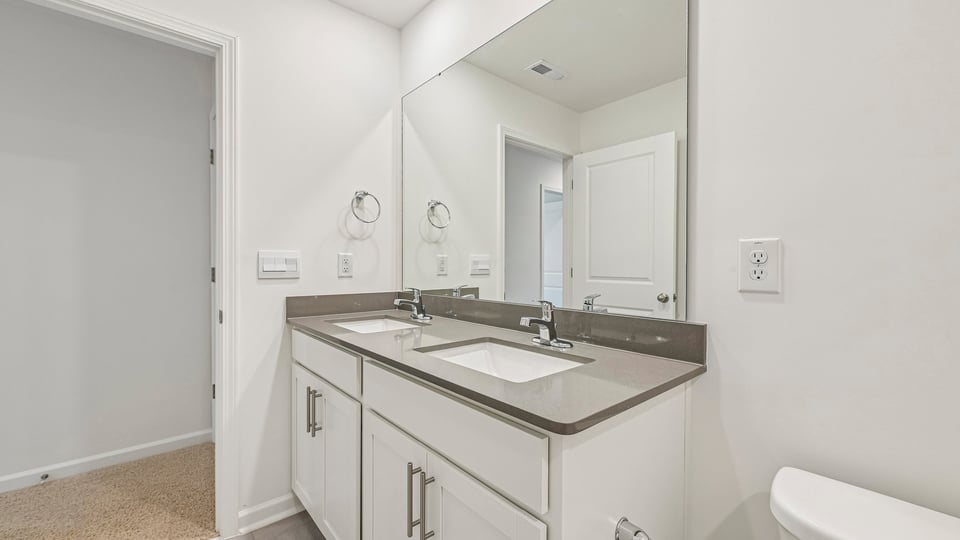 bathroom with dual vanity white cabinets and quartz countertops
