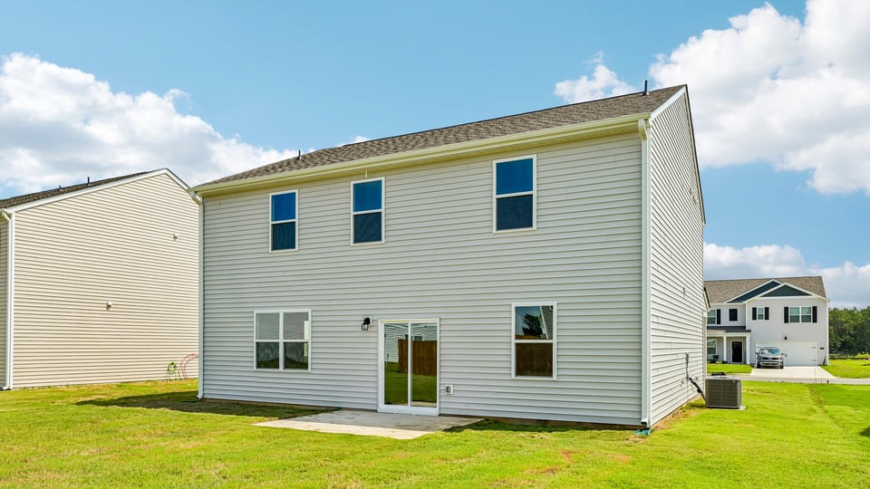 back of home with concrete patio