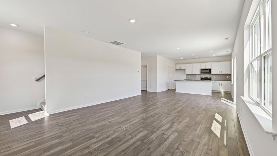 open concept living and dining areas overlooked by kitchen