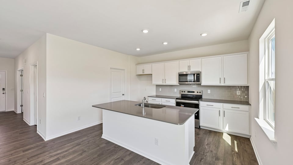 kitchen with white cabinets center island and quartz countertops