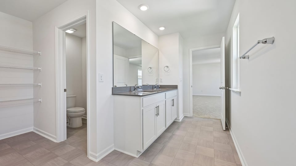 primary bathroom with dual sinks and quartz countertops