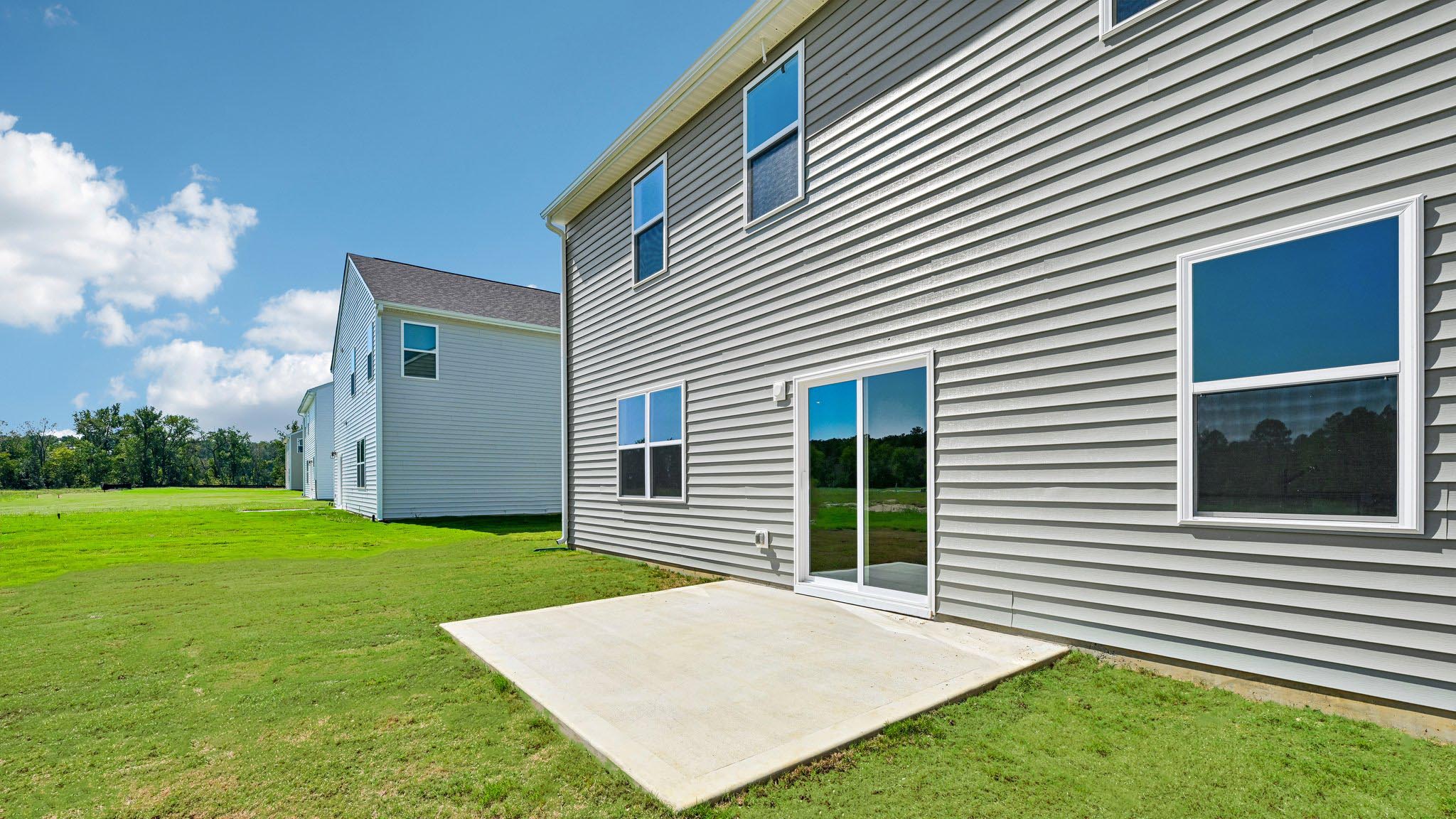 back of home with concrete patio