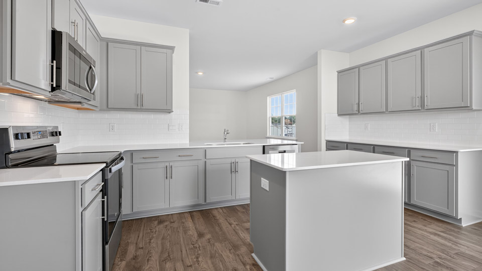 kitchen with quartz counters, kitchen island, pantry, stainless steel appliances