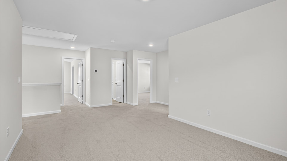 upstairs loft area with large windows and carpeting