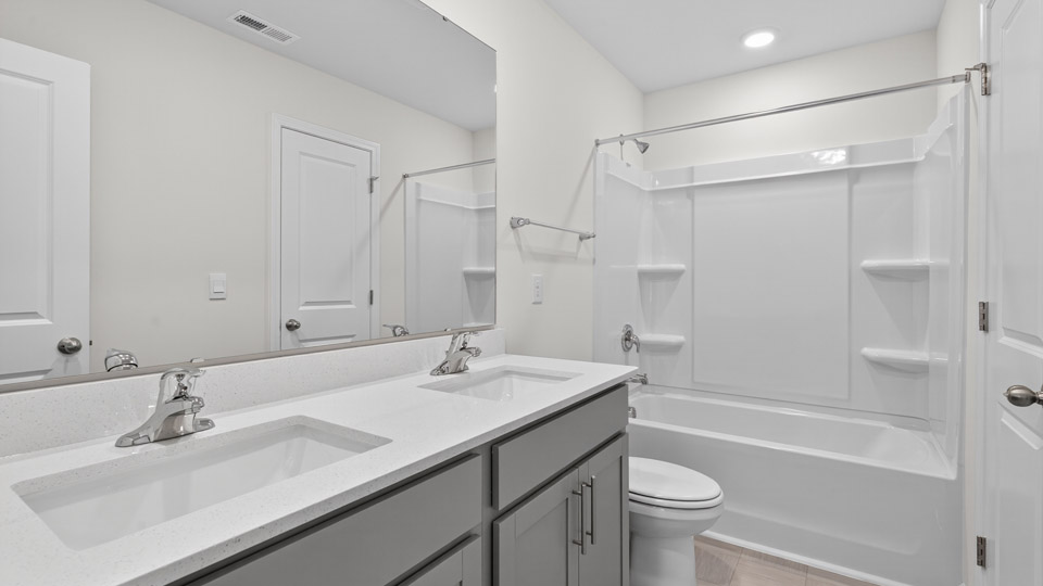 secondary bathroom with shower tub combo and dual vanity sink