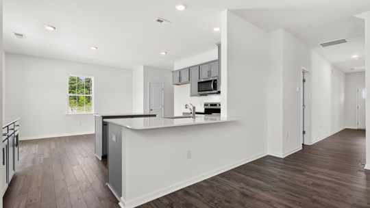 kitchen with quartz counters, kitchen island, pantry, stainless steel appliances